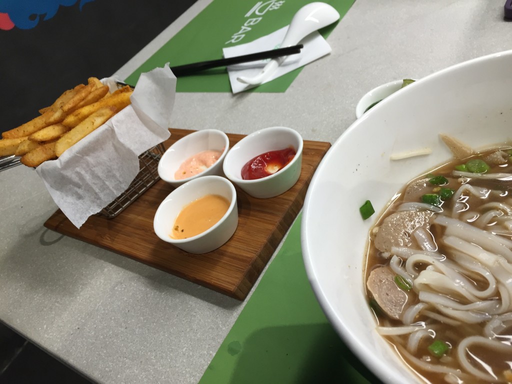 Pho and curry fries with three dipping sauces from a small establishment hidden behind a clothing stall in a narrow alley